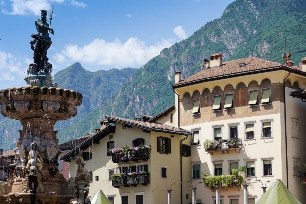 The main piazza in Trento Italy with the fountain and mountains behind it