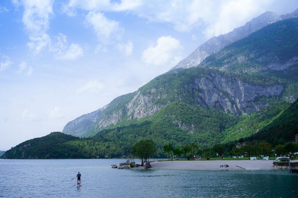 Man paddle boarding upon Lake Molveno against the epic backdrop of the Brenta Dolomites