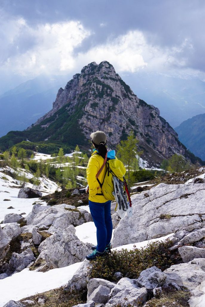 Girl in yellow coat looking out upon the Dolomiti di Brenta