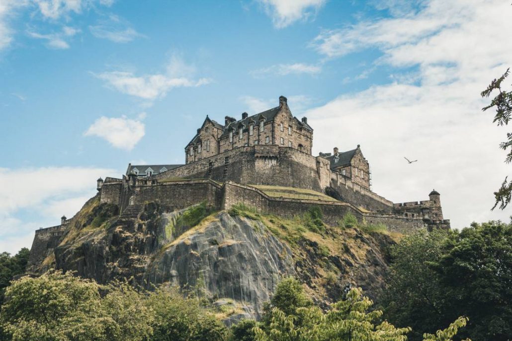 Photo of Edinburgh Castle with blue skies and white fluffy clouds in the background