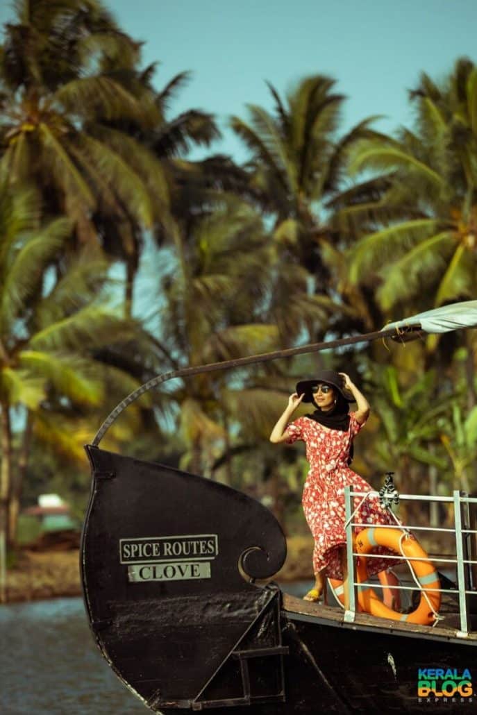 Farhana sits on the bow of the boat wearing a hat