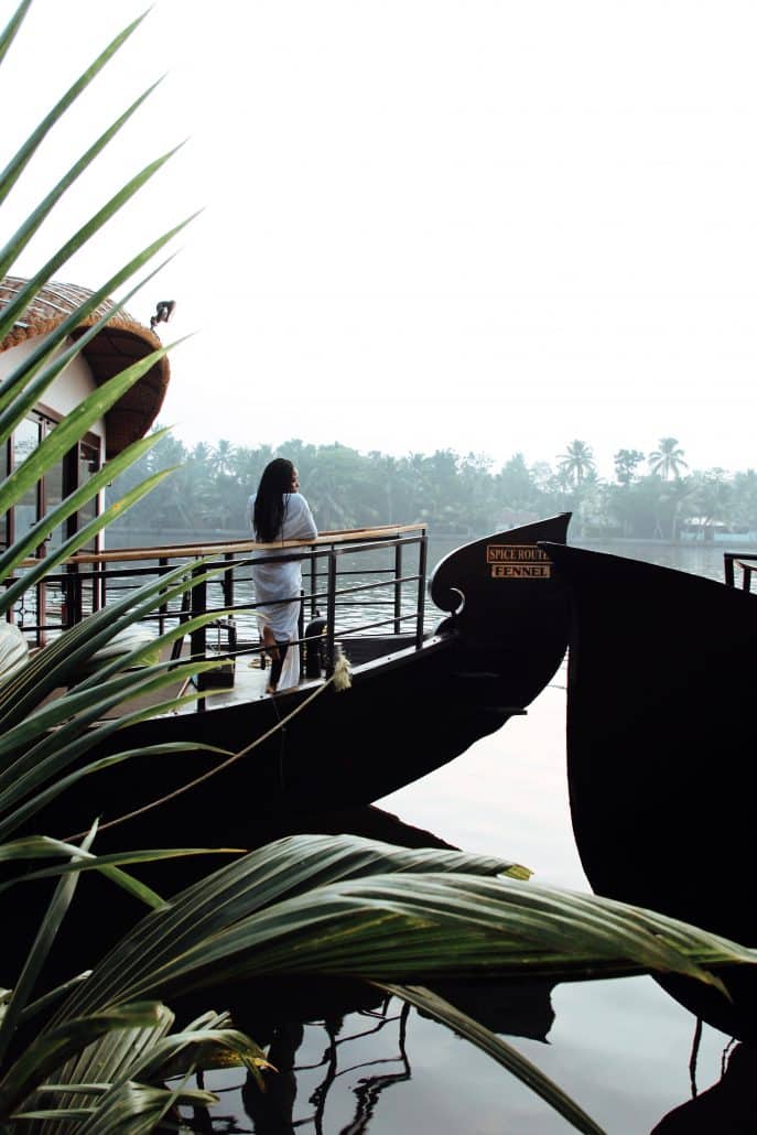 Woman stands on a houseboat in Alleppey, India