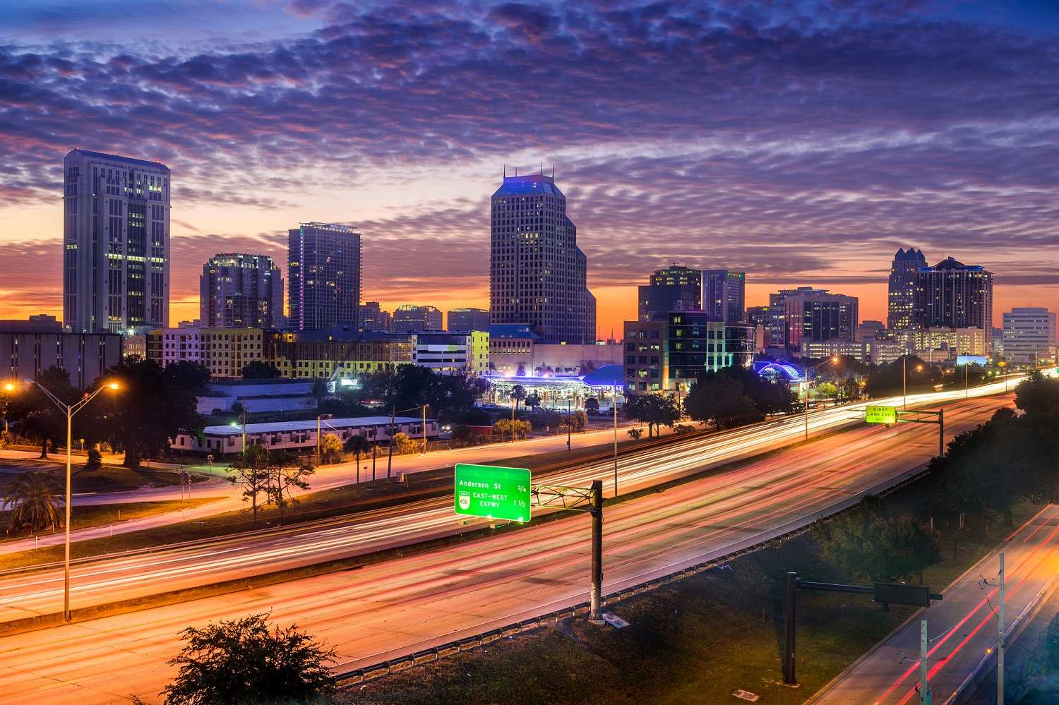 Sunset skyline in Orlando Florida with skyscrapers and a highway