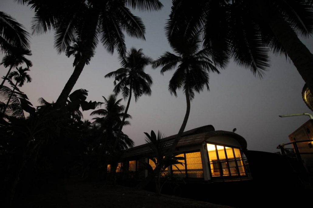 A luxury houseboat at night with its lights on