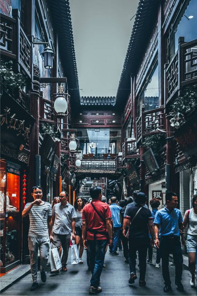 Crowd of Chinese people walking through Yu Gardens in Shanghai China in the narrow alleyways