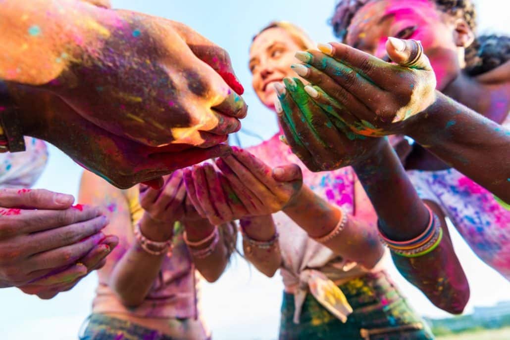 Group of women in India covered in colours celebrating Holi