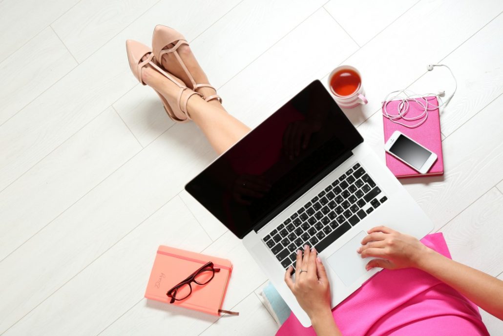 Birds' eye view of a lady dressed in pink with cute heels, starting a travel blog to remember her travel memories