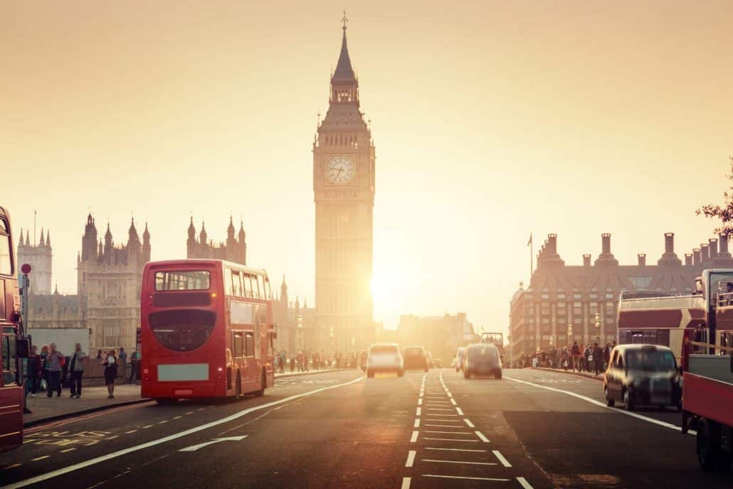 Westminster Bridge in London during sunset with Big Ben and a red bus shining bright